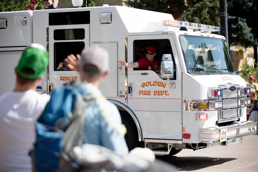 Members of the Golden Fire Department wave to people as they drive down the parade route Saturday morning.
